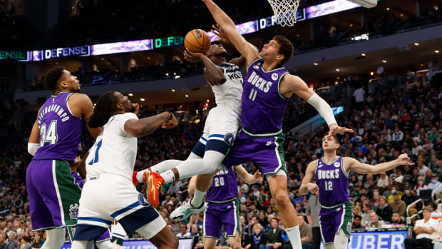 Anthony Edwards shoots a layup defended tightly by Brook Lopez